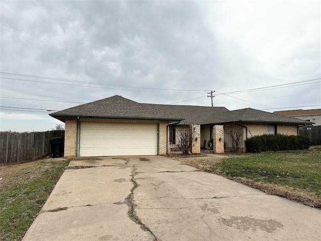 single story home featuring brick siding, an attached garage, driveway, and fence