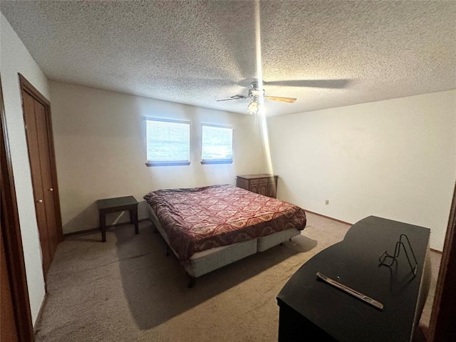 bedroom featuring a ceiling fan, carpet, and a textured ceiling