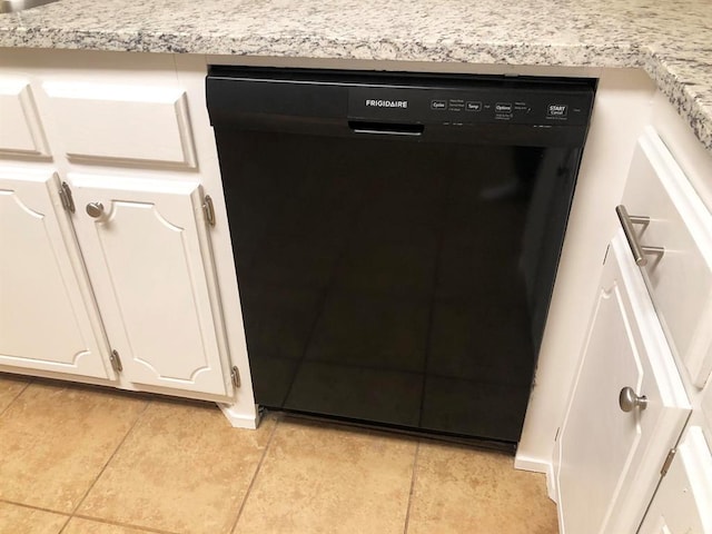 interior details featuring black dishwasher, light countertops, and white cabinetry