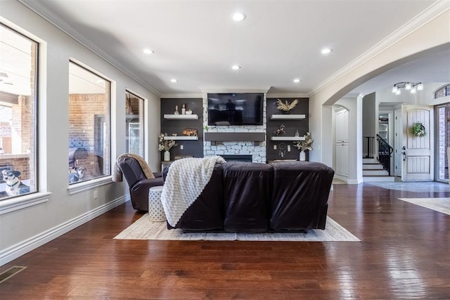 living area featuring visible vents, arched walkways, ornamental molding, and hardwood / wood-style flooring