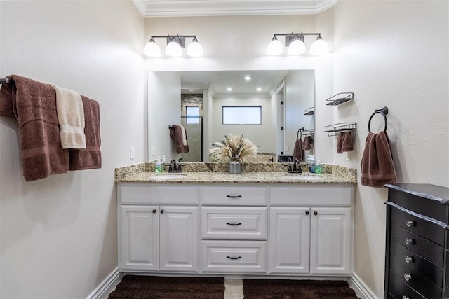 bathroom featuring a sink, baseboards, double vanity, and crown molding