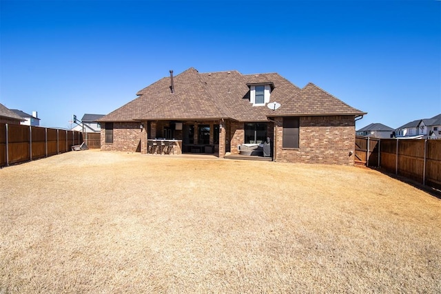 13216 Knight Island Dr, Oklahoma City, OK 73142 - rear view of property featuring a patio, brick siding, a fenced backyard, and a shingled roof