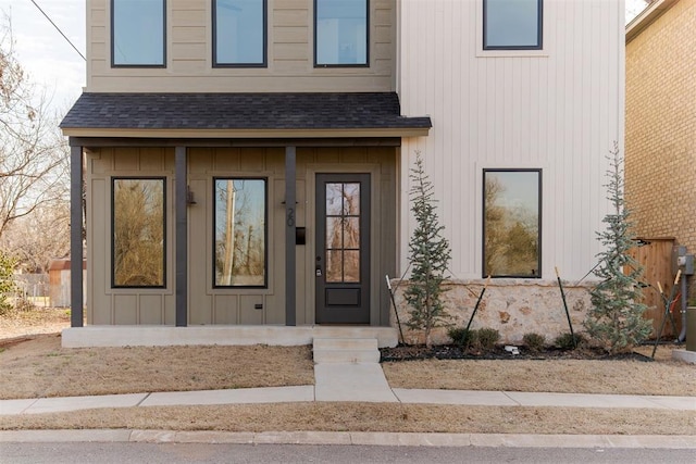 entrance to property featuring a shingled roof