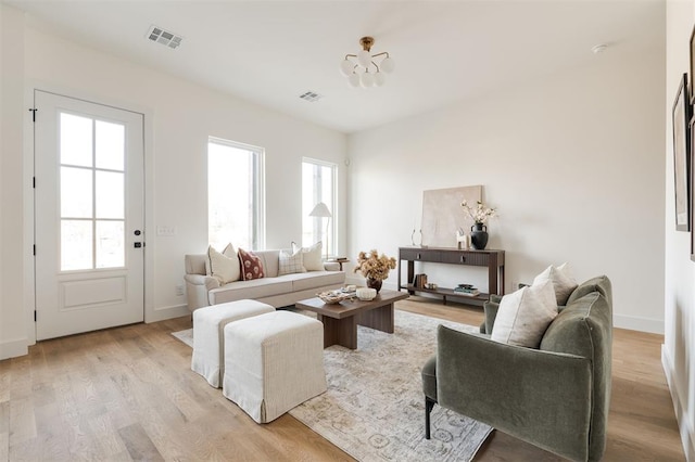 living area with visible vents, baseboards, and light wood finished floors