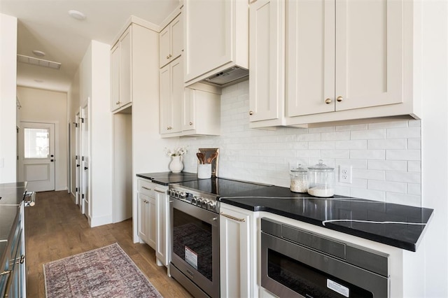 kitchen featuring dark countertops, stainless steel appliances, tasteful backsplash, and wood finished floors