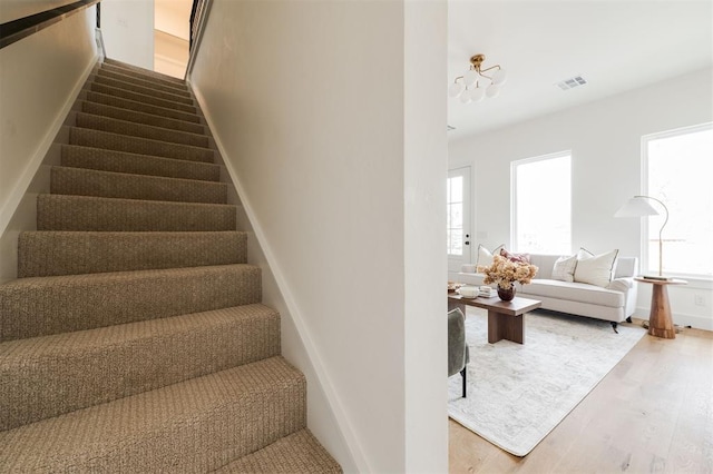 stairway with visible vents and wood finished floors