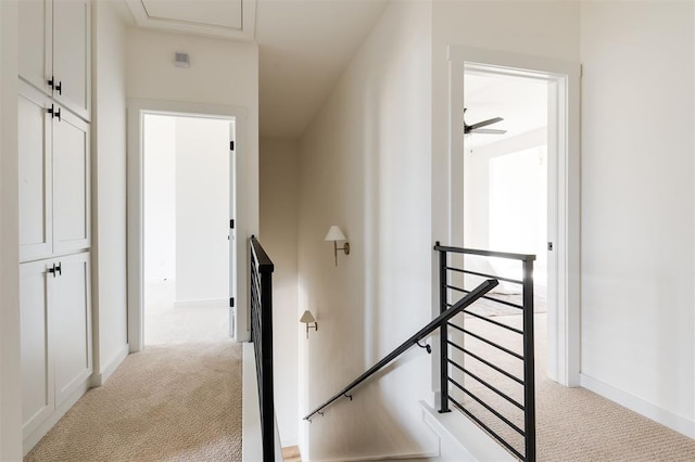 stairway featuring baseboards and carpet