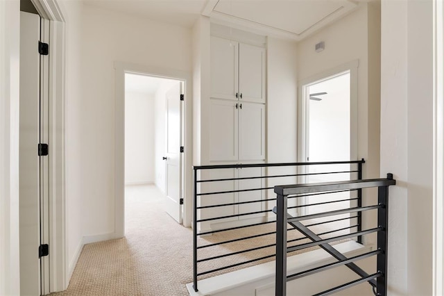 hall featuring baseboards and light colored carpet