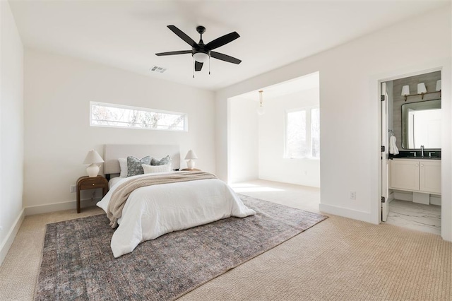 bedroom featuring a sink, visible vents, multiple windows, and light carpet