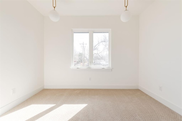 spare room with light carpet and baseboards