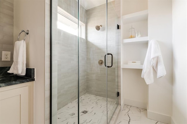 full bath featuring a shower stall, baseboards, and marble finish floor