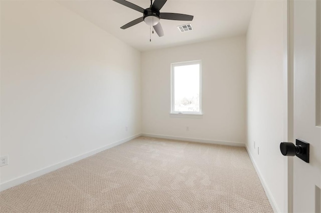 spare room with visible vents, baseboards, light colored carpet, and ceiling fan