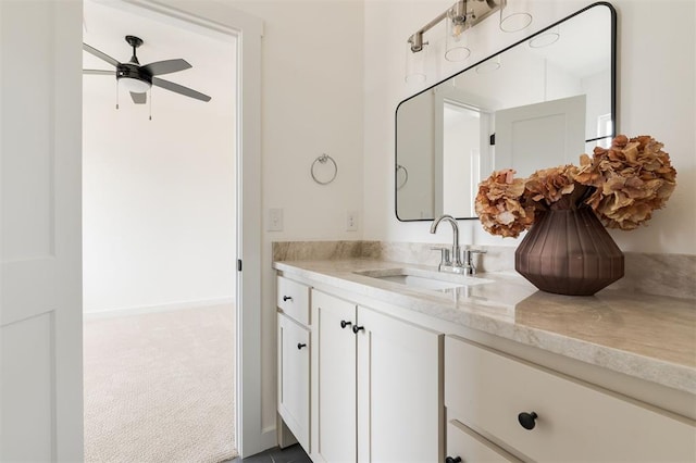 bathroom with baseboards, ceiling fan, and vanity