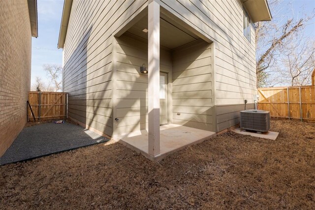 view of exterior entry featuring fence and central AC