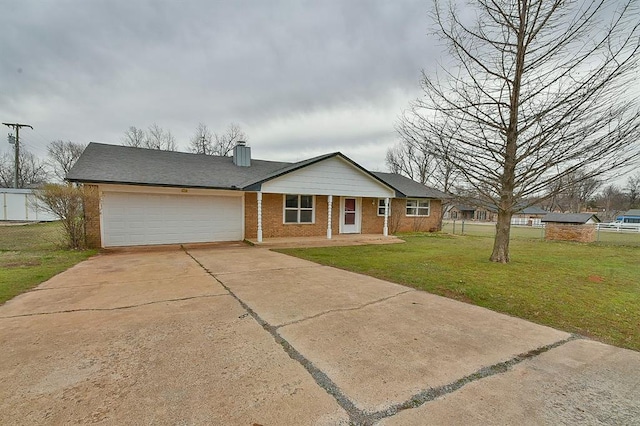 single story home featuring concrete driveway, a front yard, a garage, brick siding, and a chimney