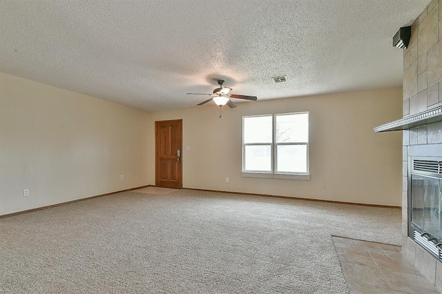 unfurnished living room with visible vents, baseboards, light colored carpet, and a tiled fireplace