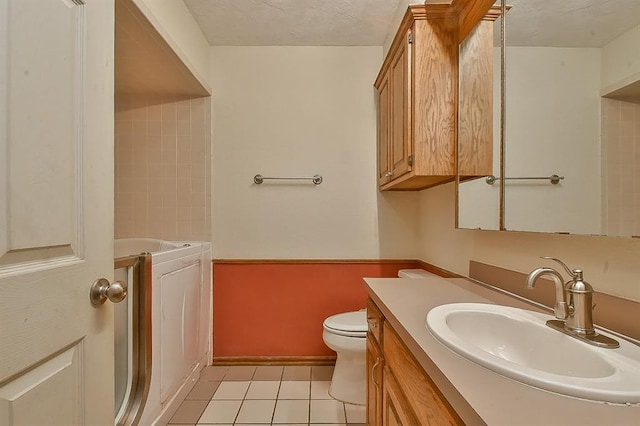 full bathroom featuring toilet, a textured ceiling, washer / clothes dryer, and vanity