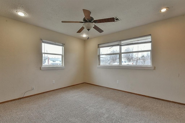 unfurnished room with carpet flooring, a ceiling fan, baseboards, and a textured ceiling