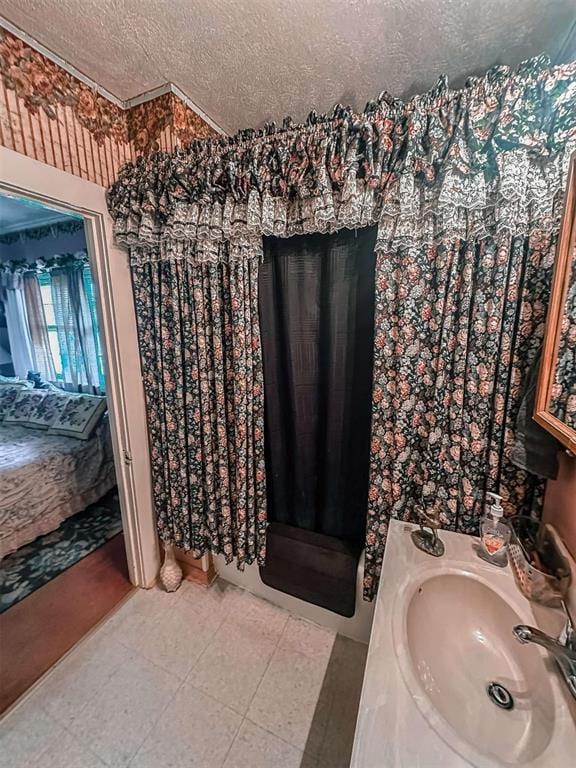 bathroom with a textured ceiling, vanity, and tile patterned flooring