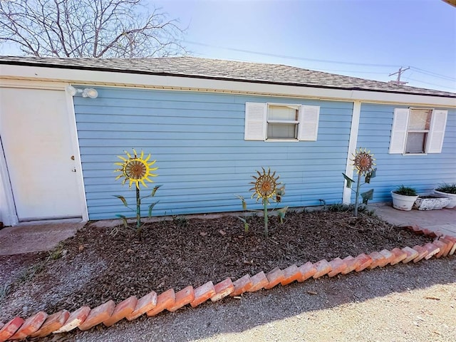 view of side of property featuring a shingled roof