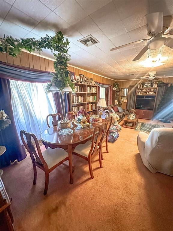623 W 4th St, Grandfield, OK 73546 - carpeted dining space featuring wooden walls and a ceiling fan