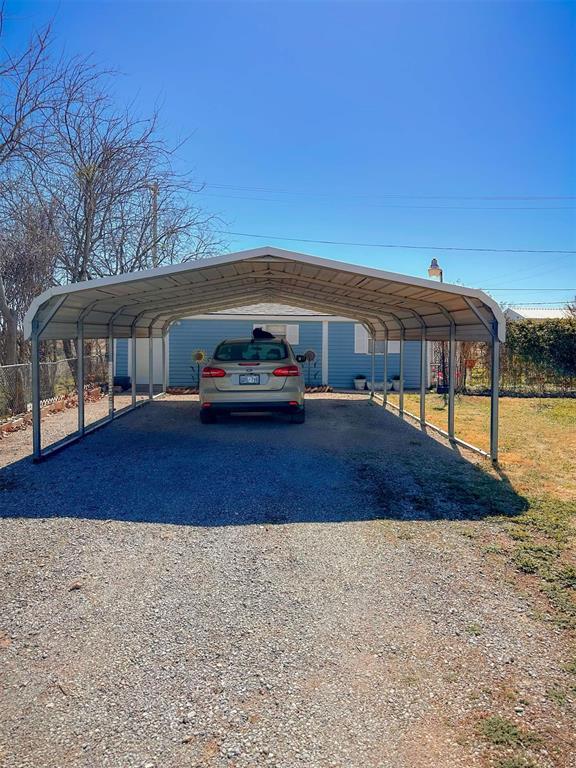 623 W 4th St, Grandfield, OK 73546 - view of parking / parking lot featuring a detached carport and gravel driveway