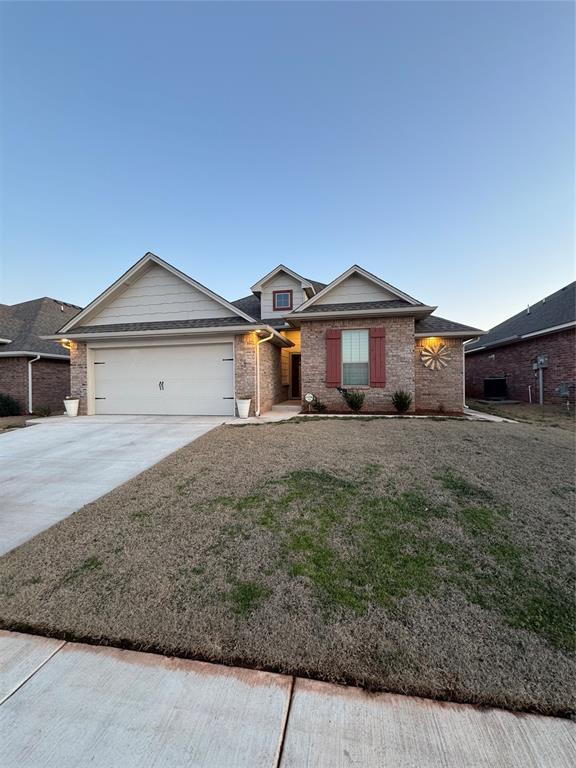 ranch-style home featuring a garage, brick siding, and driveway