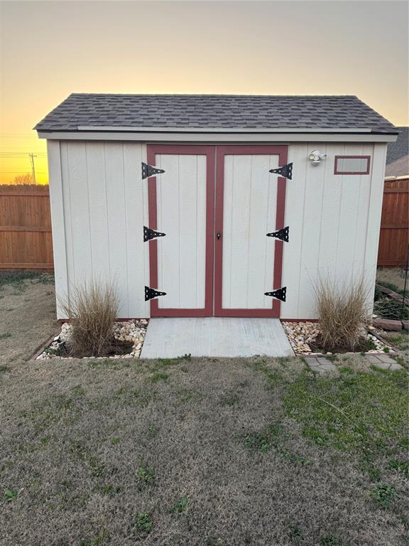 view of shed featuring fence