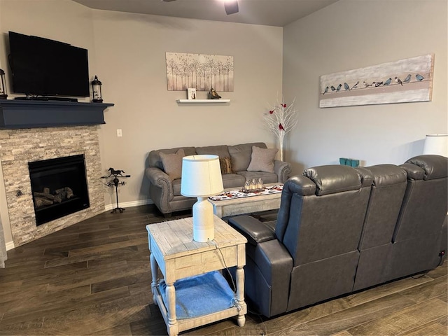 living room with a fireplace, baseboards, ceiling fan, and wood finished floors