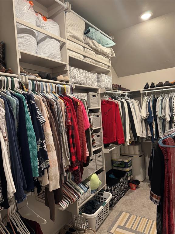 spacious closet with carpet flooring and vaulted ceiling