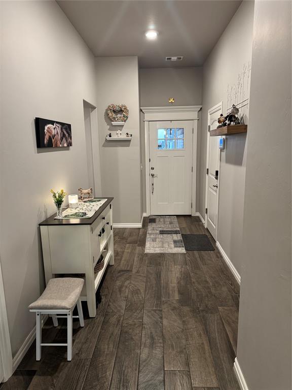 entryway with visible vents, baseboards, and dark wood finished floors