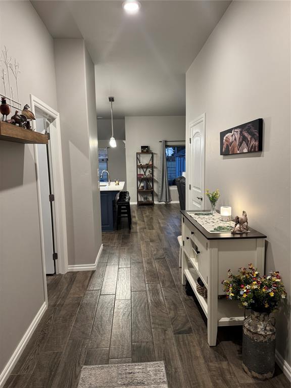 hall with baseboards and dark wood-style floors