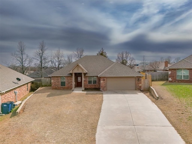 view of front of property with concrete driveway, fence, a garage, and roof with shingles