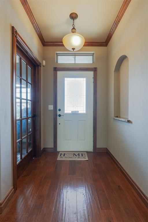 foyer featuring ornamental molding, baseboards, and hardwood / wood-style flooring