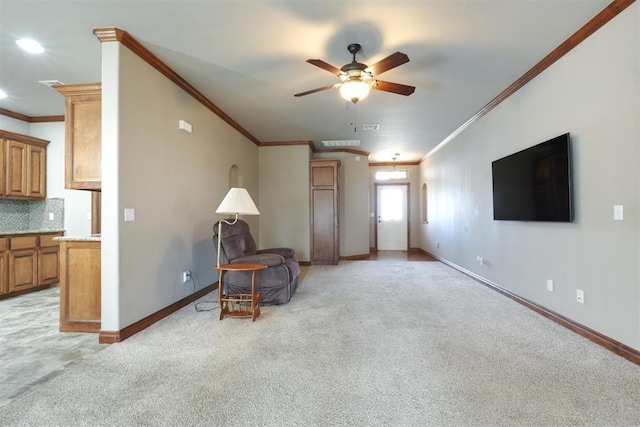 living area featuring baseboards, light carpet, a ceiling fan, and crown molding