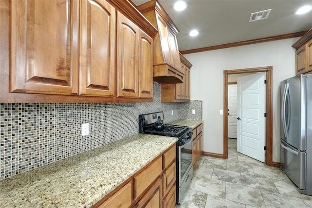 kitchen featuring visible vents, light stone counters, stainless steel appliances, crown molding, and decorative backsplash