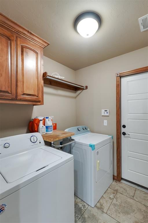 laundry room with visible vents, cabinet space, and washing machine and clothes dryer