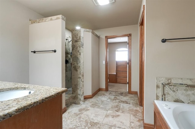 full bathroom featuring vanity, a garden tub, baseboards, and a tile shower