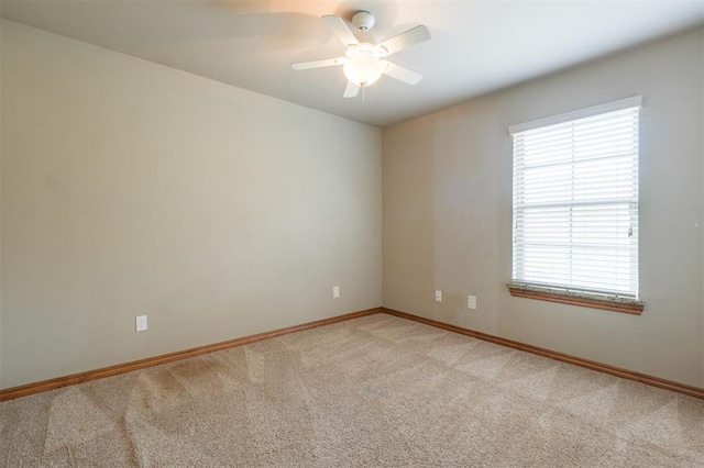 spare room featuring baseboards, light carpet, and ceiling fan