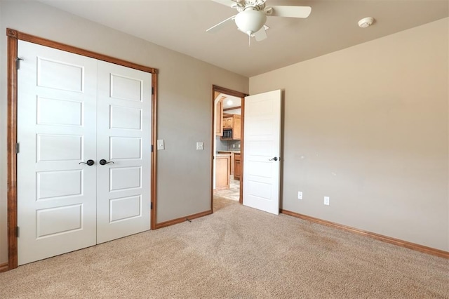 unfurnished bedroom featuring baseboards, light carpet, a closet, and ceiling fan