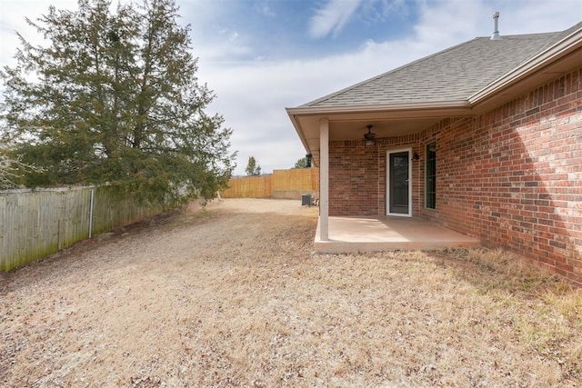 view of yard featuring a patio, central air condition unit, and a fenced backyard