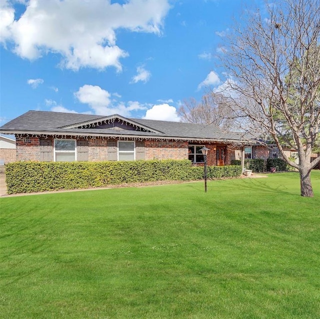 ranch-style house with a front lawn and brick siding