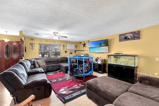 living room with visible vents, a textured ceiling, and a ceiling fan