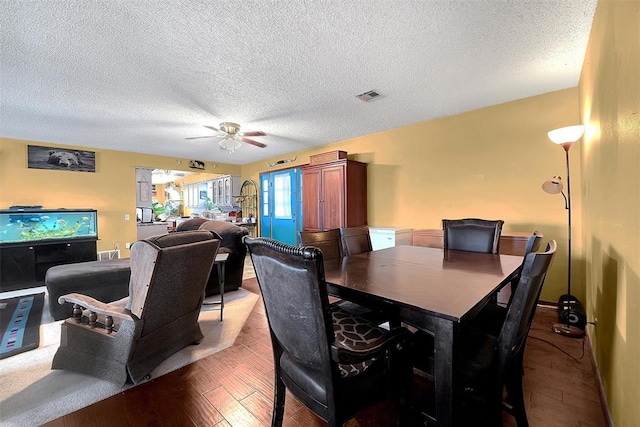 dining area featuring visible vents, a textured ceiling, a ceiling fan, and hardwood / wood-style flooring