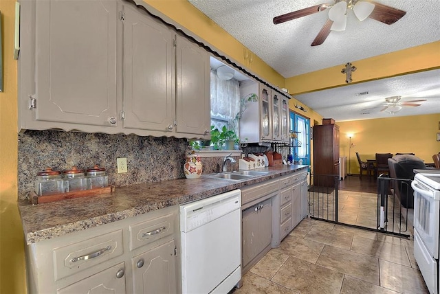 kitchen with a ceiling fan, a sink, tasteful backsplash, a textured ceiling, and white appliances