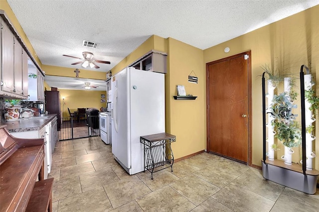 kitchen with white appliances, visible vents, a sink, ceiling fan, and a textured ceiling