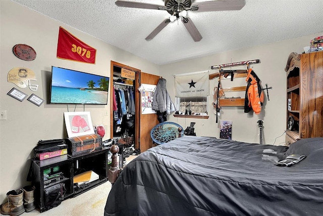 bedroom with a closet, a textured ceiling, carpet, and a ceiling fan