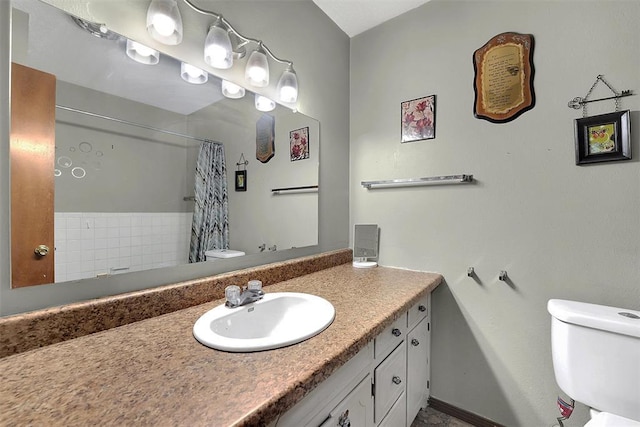 bathroom featuring a shower with curtain, toilet, and vanity