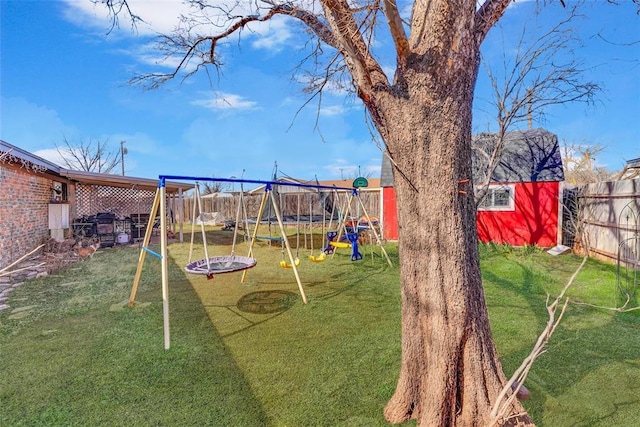 view of jungle gym with a yard, an outdoor structure, and a fenced backyard