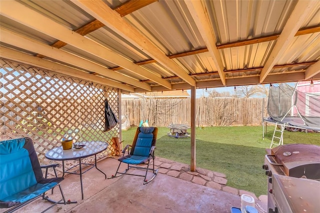 view of patio featuring area for grilling, a trampoline, and a fenced backyard